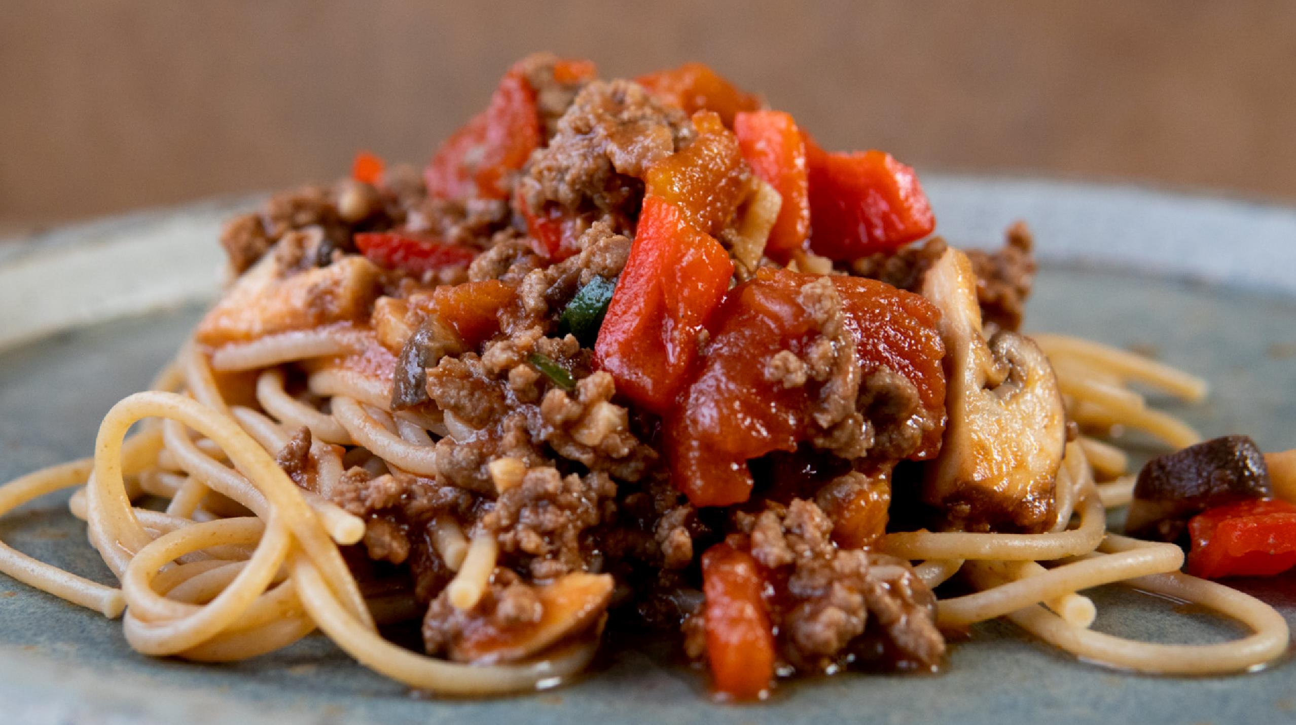 Bord med tallerken hvorpå der er spaghetti bolognese