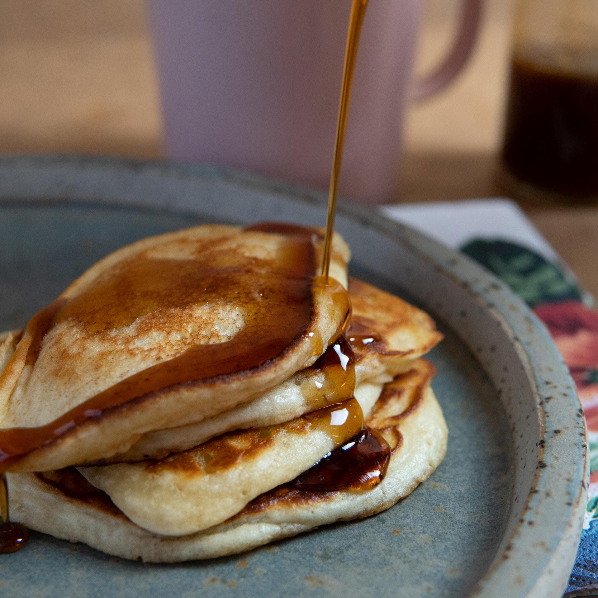 Billede af tallerken med pandekager hvorover der hældes kaffesirup