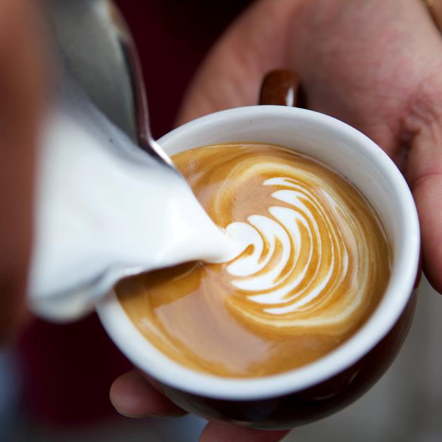 Kop med espresso i og mælk der laves til latteart